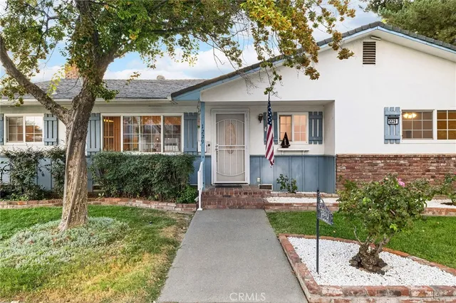 a front view of a house with a yard and trees
