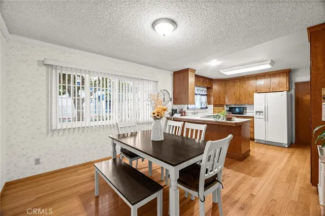 a kitchen with a dining table chairs and refrigerator