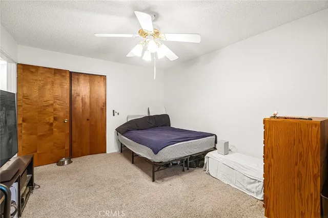 a spacious bedroom with a bed and a chandelier