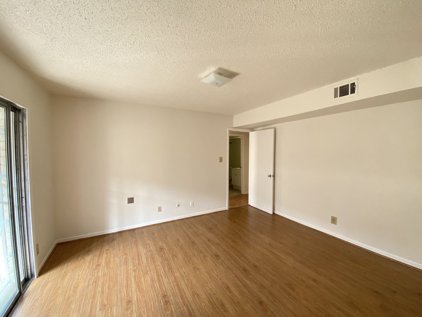 6201 Ranchester Drive, Unit 19 Houston, TX 77036 - Photo 11 of 26 an empty room with wooden floor and windows