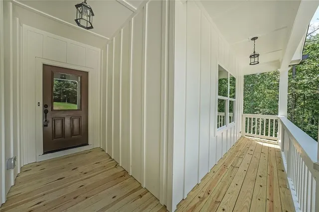 a view of a hallway with wooden floor and stairs
