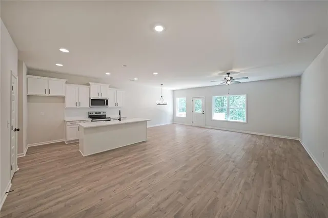 a view of kitchen with kitchen island granite countertop a stove top oven a sink and a refrigerator