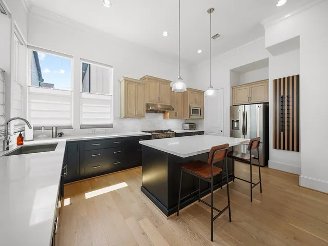 a kitchen with stainless steel appliances granite countertop a sink a stove a refrigerator and island with wooden floor