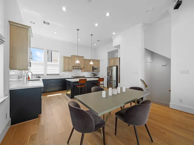 a kitchen with a dining table chairs and refrigerator