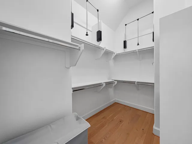 a view of walk in closet with empty racks