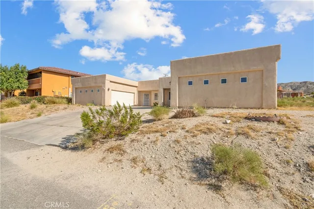 a large white house with a big yard and large trees