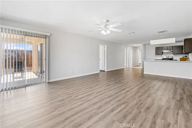 a view of a livingroom with wooden floor and a ceiling fan