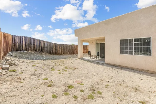 a view of backyard with barbeque grill and wooden fence