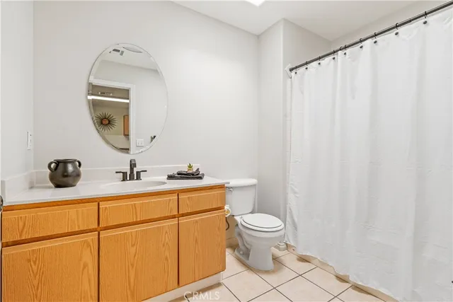 a bathroom with a granite countertop sink vanity mirror and toilet