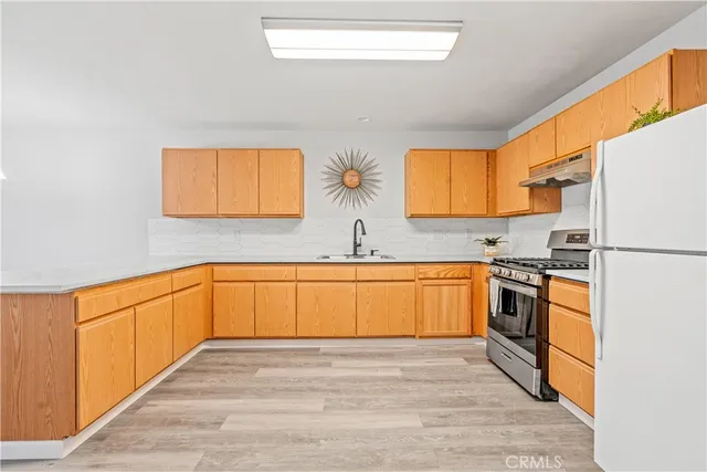 a kitchen with stainless steel appliances granite countertop a sink and a stove top oven