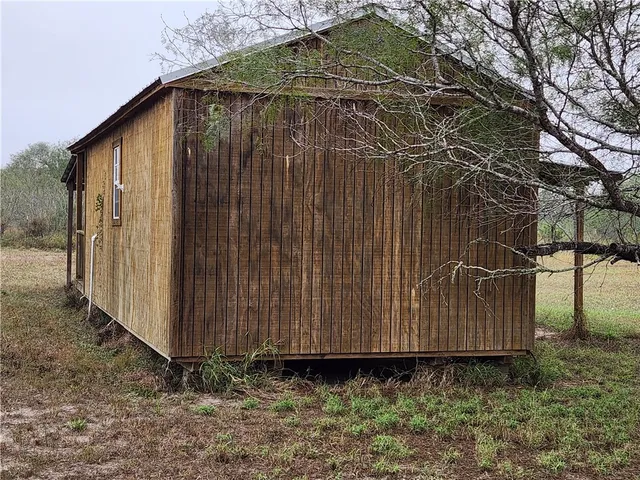 a view of a small barn with wooden fence