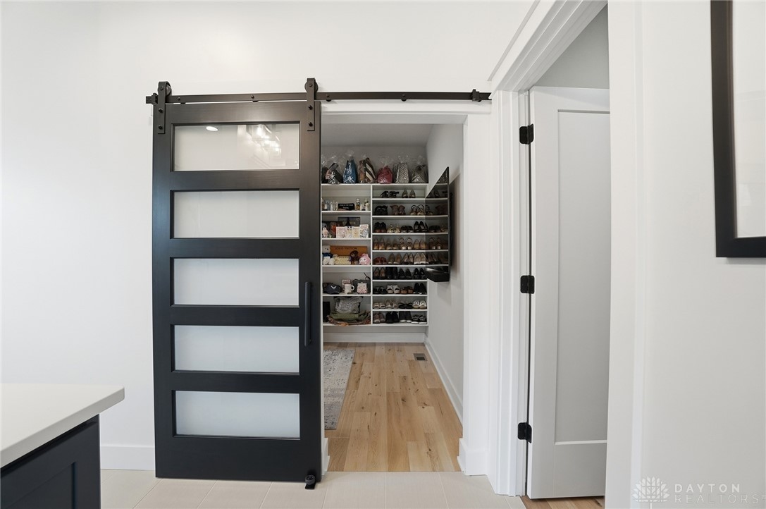 1247 Normandy Rue Dayton, OH 45458 - Photo 27 of 76 An elegant barn door reveals a meticulously organized walk-in closet with ample storage.