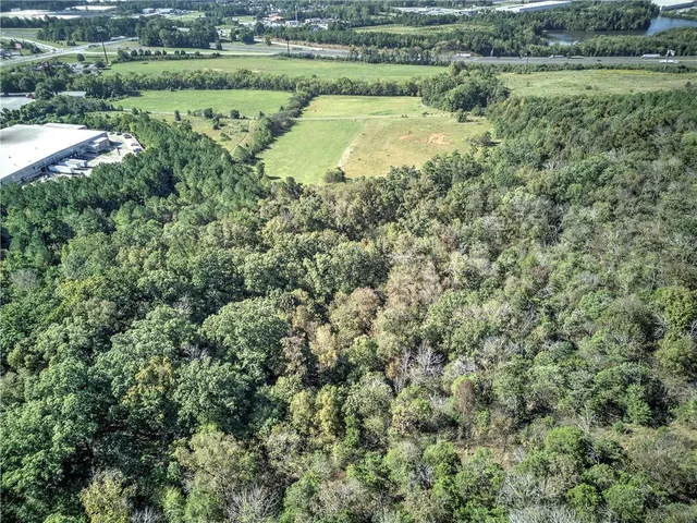 an aerial view of residential houses with outdoor space and trees