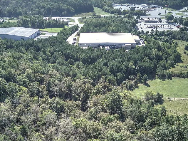 an aerial view of residential houses with outdoor space and trees