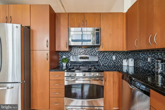 a kitchen with granite countertop a refrigerator stove and microwave