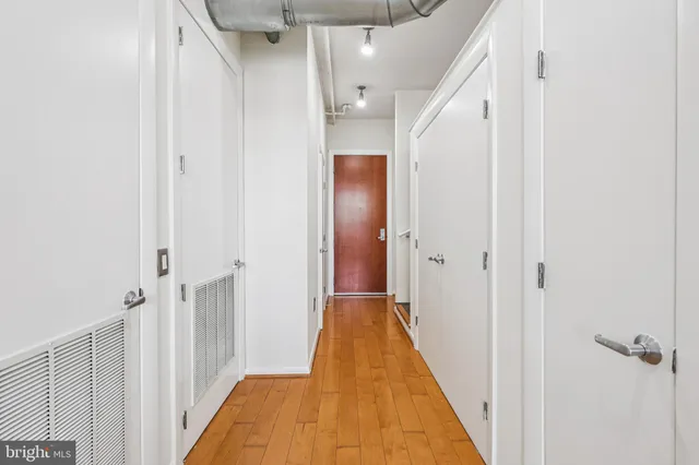a view of a hallway with wooden floor and staircase