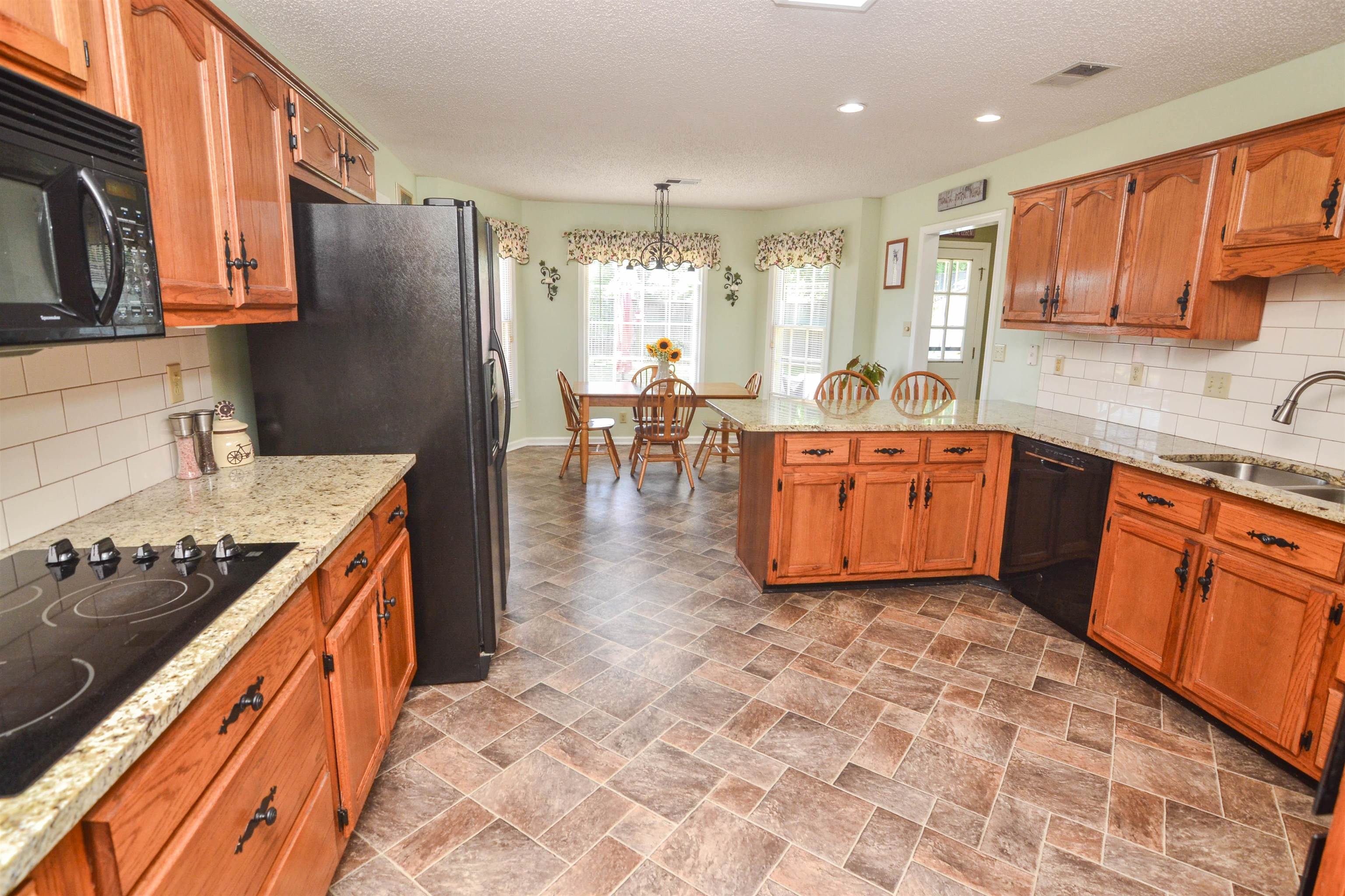 591 Rillbrook Drive Collierville, TN 38017 - Photo 7 of 25 a kitchen with stainless steel appliances granite countertop a stove top oven a sink dishwasher and a refrigerator
