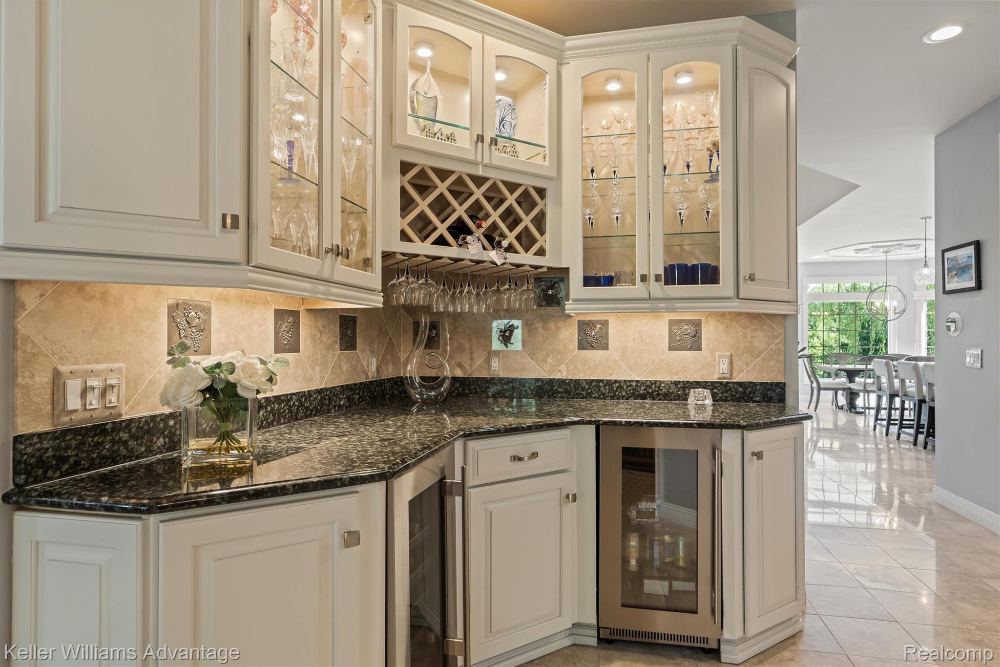 22878 Tree Top Court South Lyon, MI 48178 - Photo 12 of 75 Integrated bar area featuring granite countertops, under-cabinet lighting, a built-in wine cooler, a wine rack, and glass-front display cabinetry with interior lighting