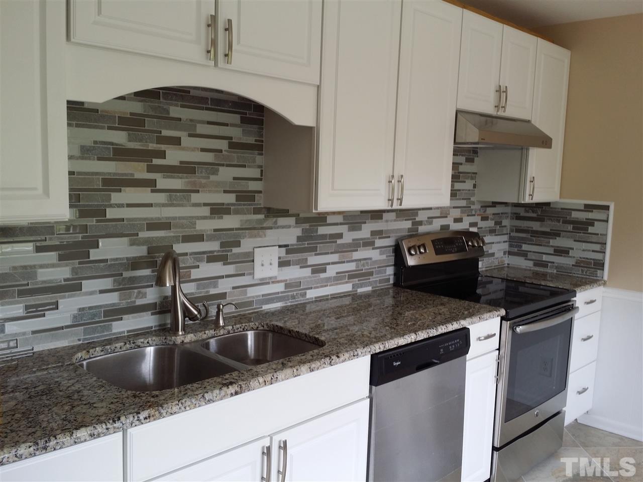 1114 North King Charles Road Raleigh, NC 27610 - Photo 2 of 13 a kitchen with granite countertop a sink stove and cabinets