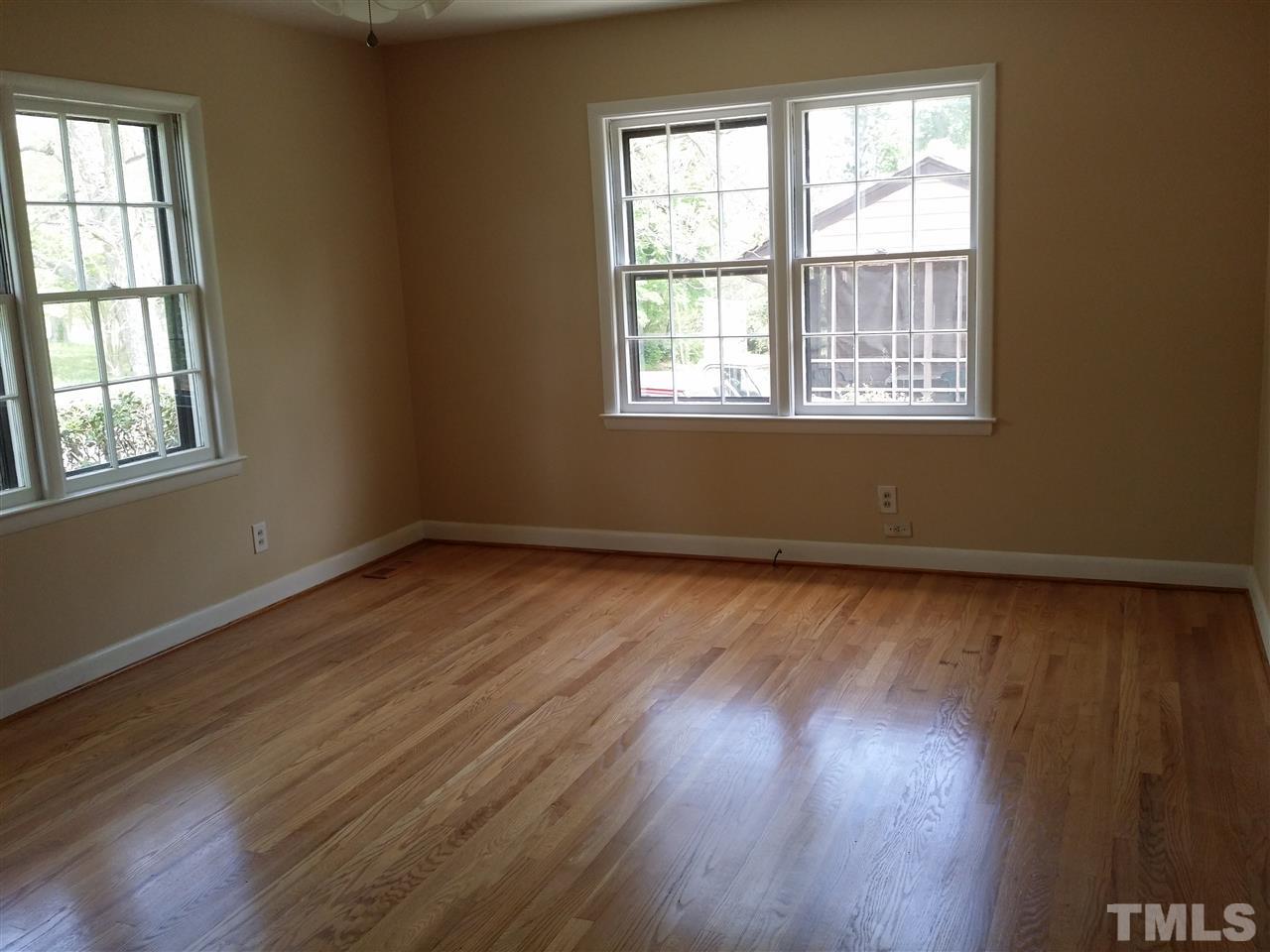 1114 North King Charles Road Raleigh, NC 27610 - Photo 4 of 13 an empty room with wooden floor and windows