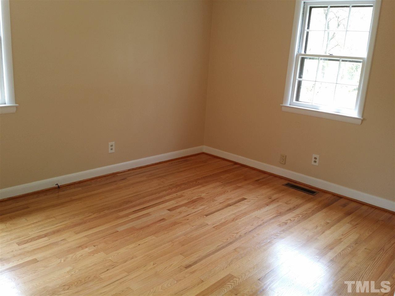 1114 North King Charles Road Raleigh, NC 27610 - Photo 5 of 13 an empty room with wooden floor and windows