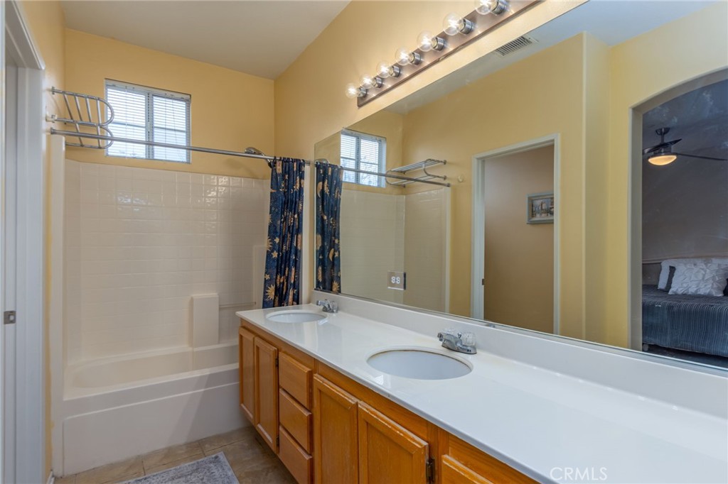 1654 Rush Haven Way Simi Valley, CA 93065 - Photo 20 of 32 a bathroom with a granite countertop sink a mirror and a bathtub