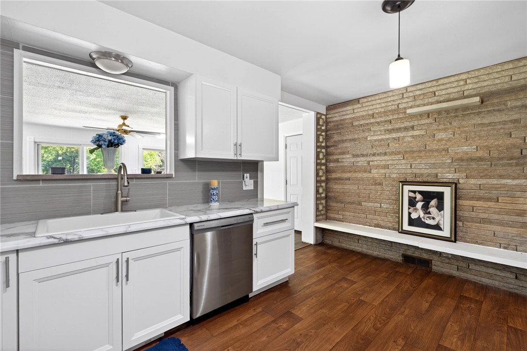 2684 Arthur Road Springfield, OH 45502 - Photo 17 of 69 This renovated kitchen features sleek white cabinetry and warm wood flooring, offering both style and functionality.