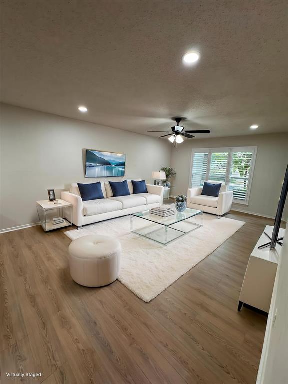 a living room with furniture and a wooden floor