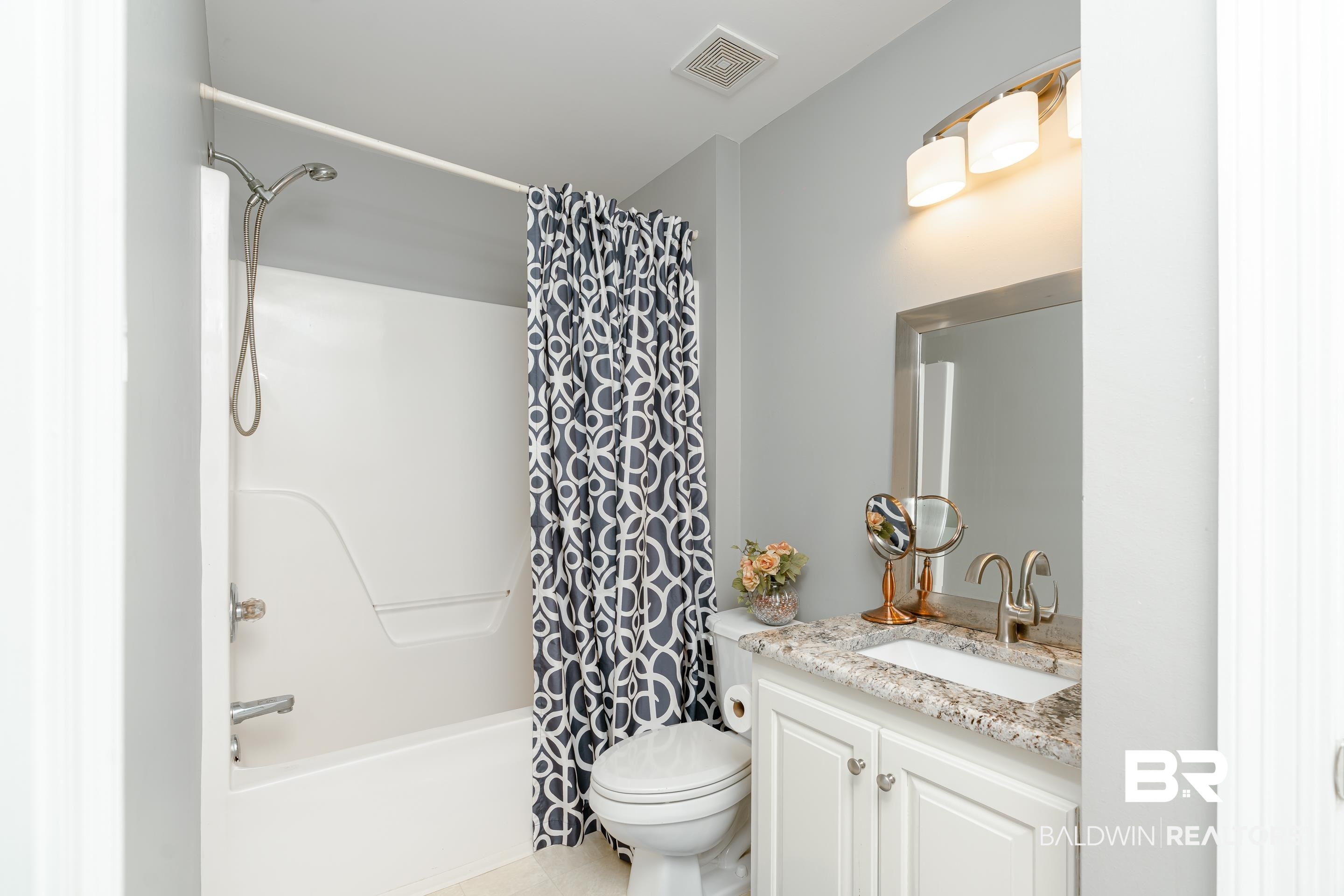9477 Deerfield Drive Irvington, AL 36544 - Photo 28 of 58 Full bathroom featuring shower / bath combination with curtain, toilet, and vanity