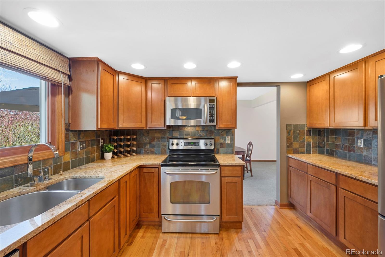 7975 Sweet Water Road Lone Tree, CO 80124 - Photo 13 of 43 a kitchen with stainless steel appliances a stove sink and cabinets