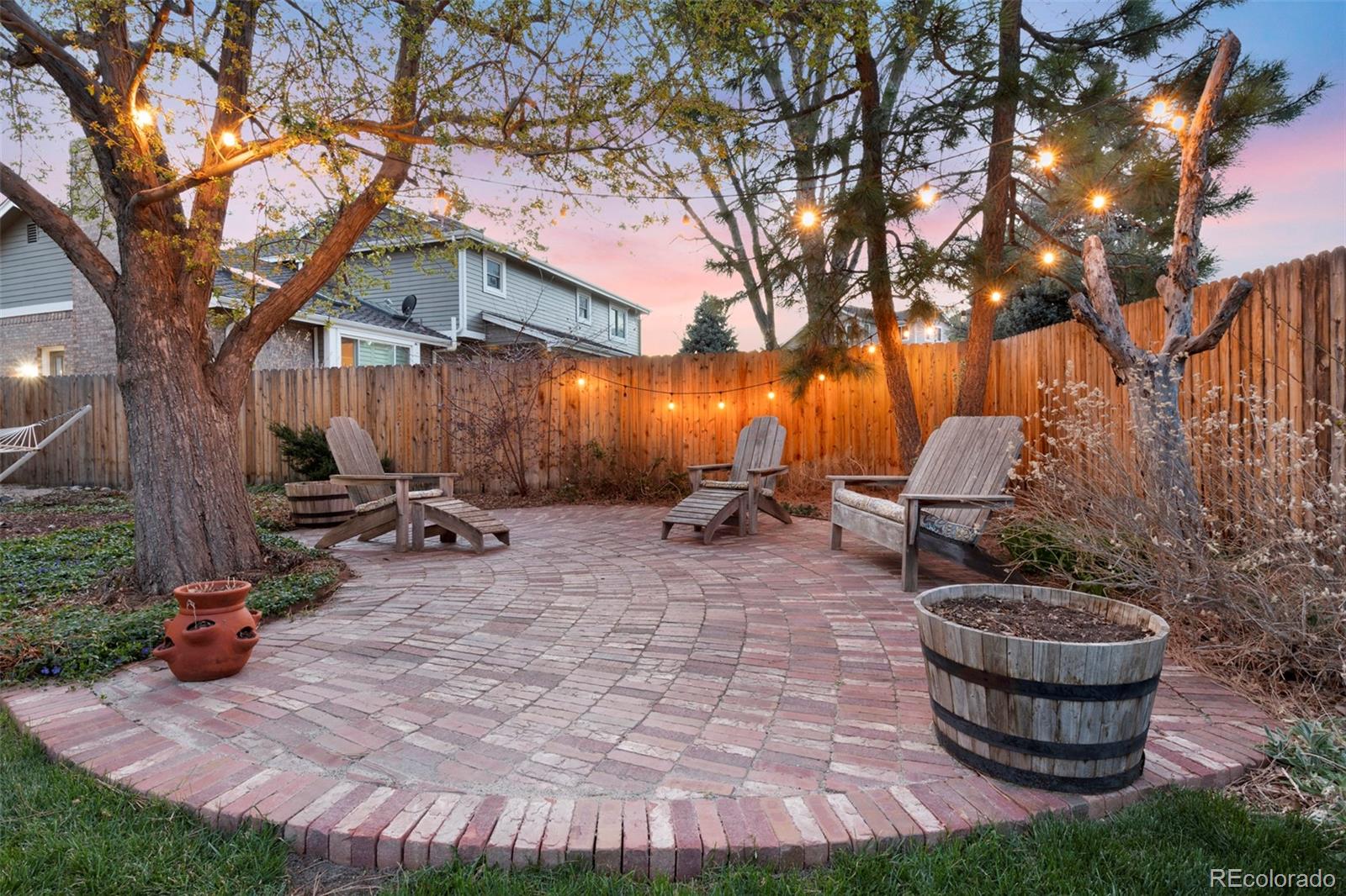 7975 Sweet Water Road Lone Tree, CO 80124 - Photo 2 of 43 a view of a backyard with table and chairs potted plants and a large tree