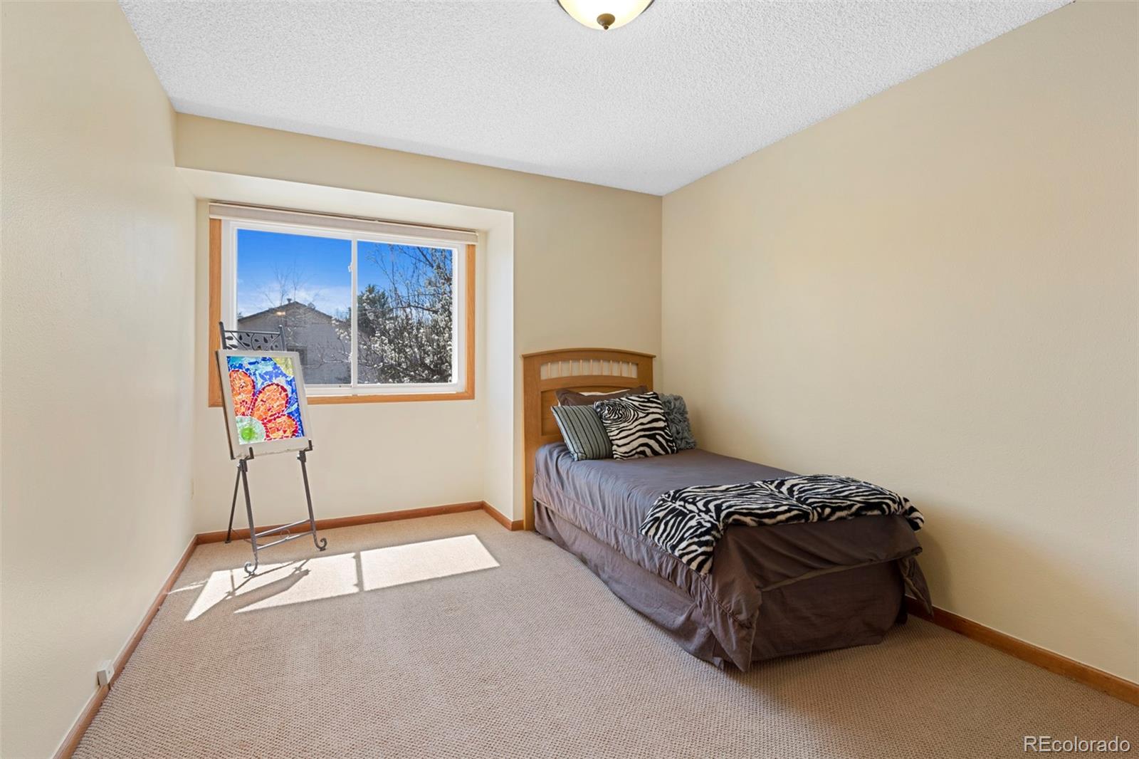 7975 Sweet Water Road Lone Tree, CO 80124 - Photo 33 of 43 a bedroom with a bed and a painting on the wall