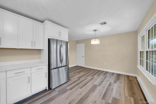 a view of a kitchen with wooden floor and electronic appliances