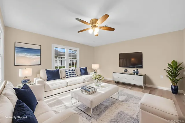 a living room with furniture a flat screen tv and a window