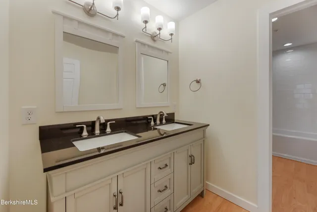 a bathroom with double sink and a mirror
