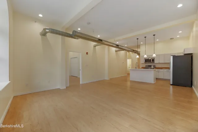 a view of a kitchen with a refrigerator and a ceiling fan