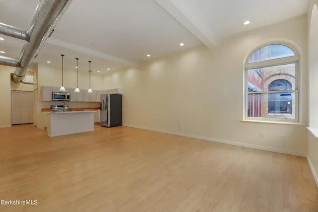 a view of an empty room with a kitchen