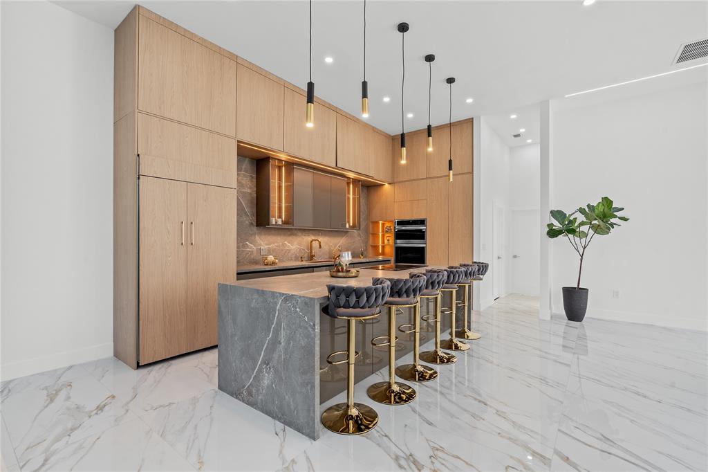 7141 Mariana Court Boca Raton, FL 33433 - Photo 19 of 68 a kitchen with stainless steel appliances kitchen island granite countertop a table chairs in it and wooden floors