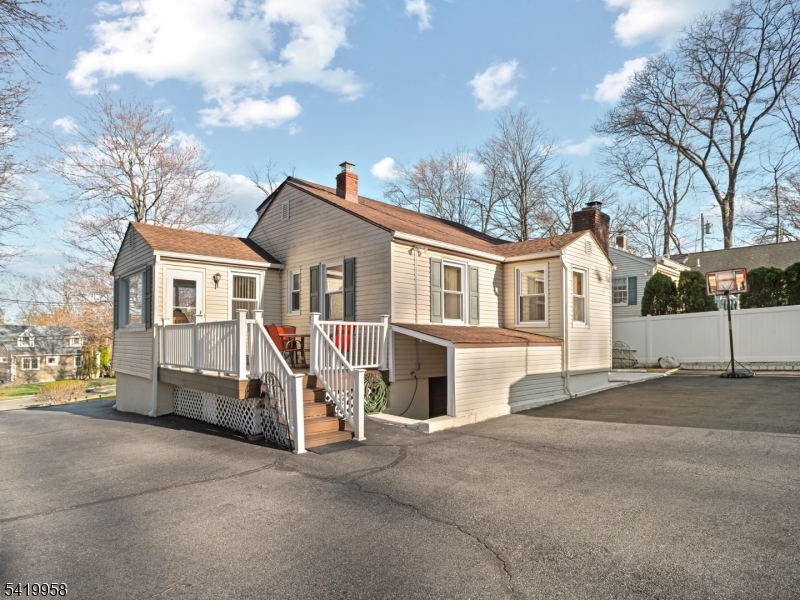 544 Goffle Hill Road Hawthorne, NJ 07506 - Photo 19 of 21 a view of a white house with a large tree and wooden fence