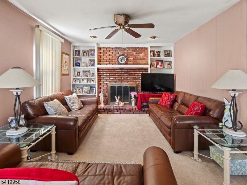 544 Goffle Hill Road Hawthorne, NJ 07506 - Photo 3 of 21 a living room with furniture a flat screen tv and a fireplace