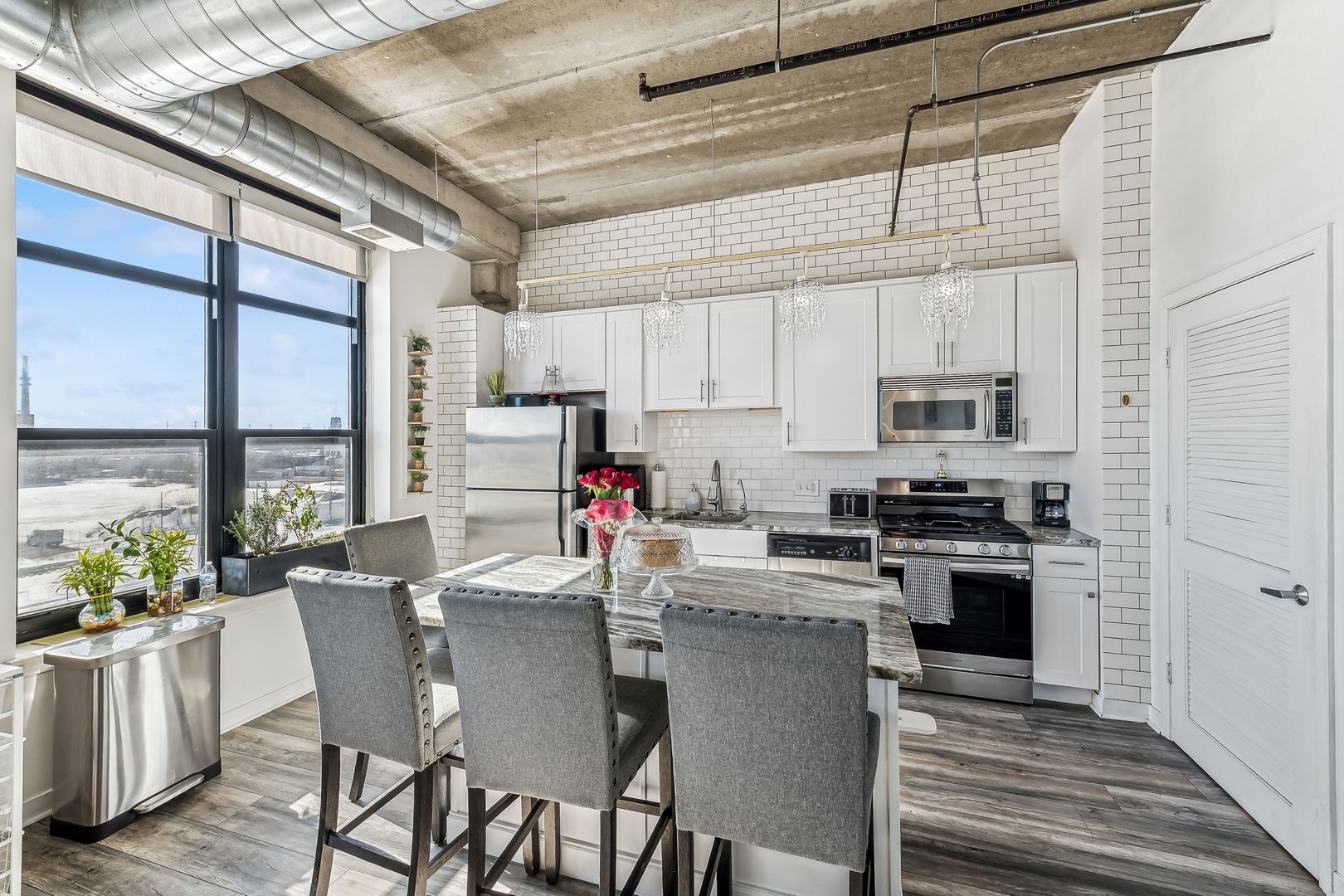 833 West 15th Place, Unit 511 Chicago, IL 60608 - Photo 5 of 16 a kitchen with microwave a stove a table and chairs in it