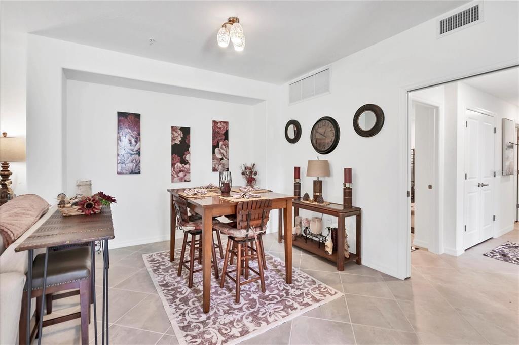 14149 Poppy Field Loop, Unit 6011 Punta Gorda, FL 33955 - Photo 11 of 63 a view of a dining room and livingroom with furniture wooden floor and a rug