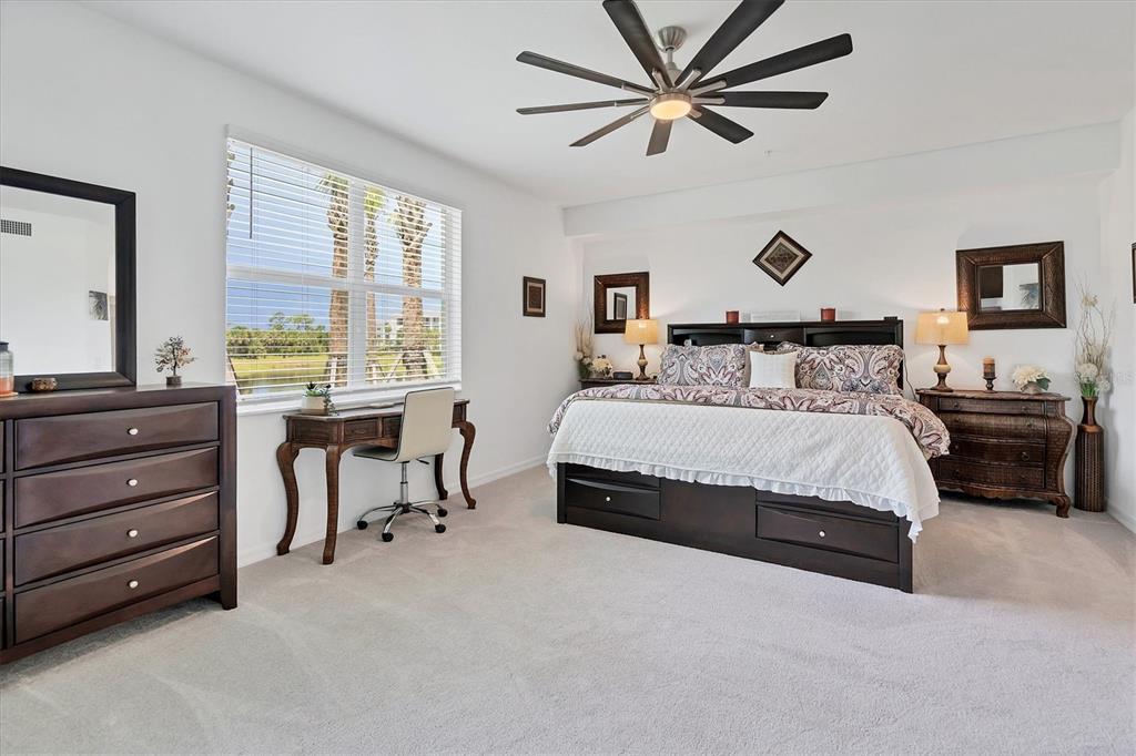 14149 Poppy Field Loop, Unit 6011 Punta Gorda, FL 33955 - Photo 13 of 63 a spacious bedroom with a bed a large window and a chandelier