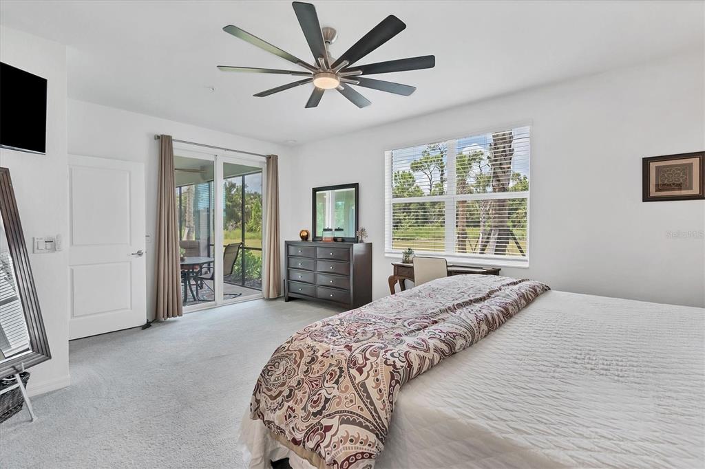 14149 Poppy Field Loop, Unit 6011 Punta Gorda, FL 33955 - Photo 15 of 63 a spacious bedroom with a large bed and a flat tv screen
