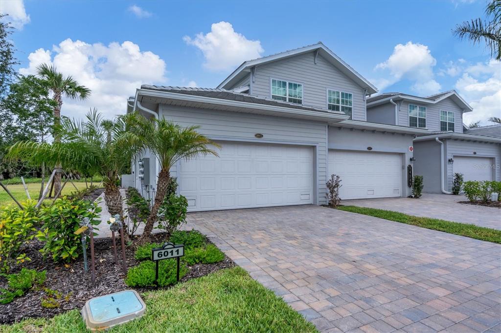 14149 Poppy Field Loop, Unit 6011 Punta Gorda, FL 33955 - Photo 29 of 63 a front view of a house with a yard and garage