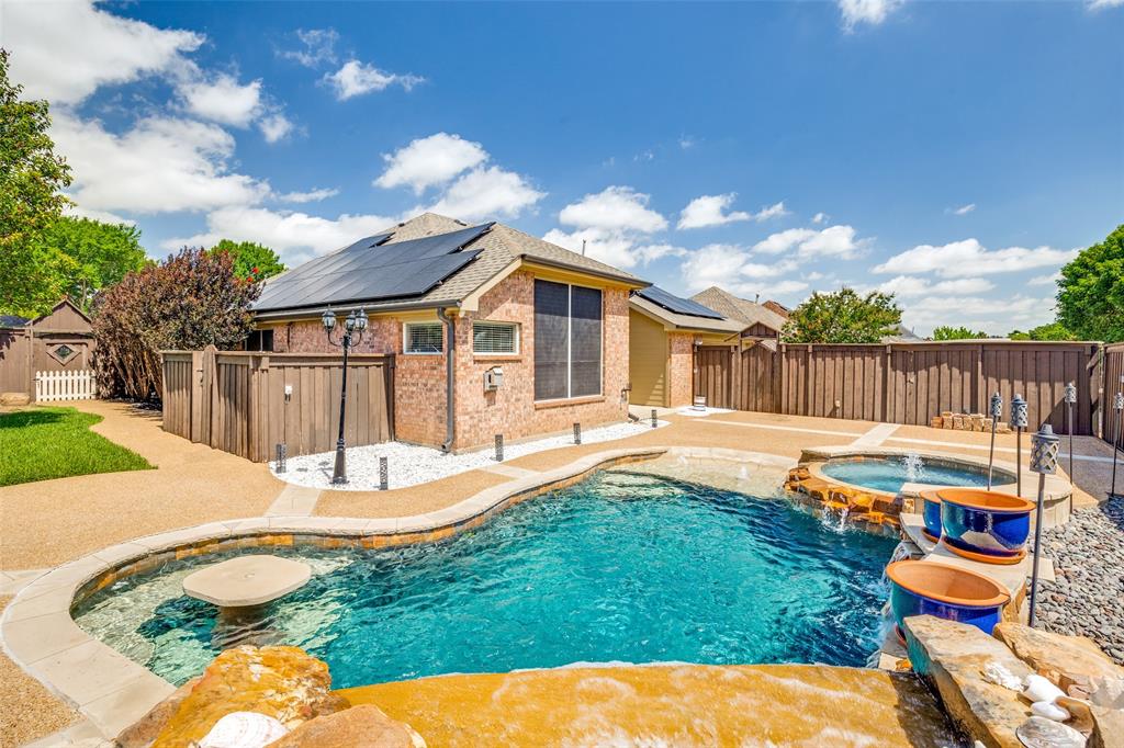 2100 Los Rios Boulevard Plano, TX 75074 - Photo 24 of 25 Resort-style backyard featuring a freeform swimming pool, integrated spa with rock waterfall, and an in-pool table