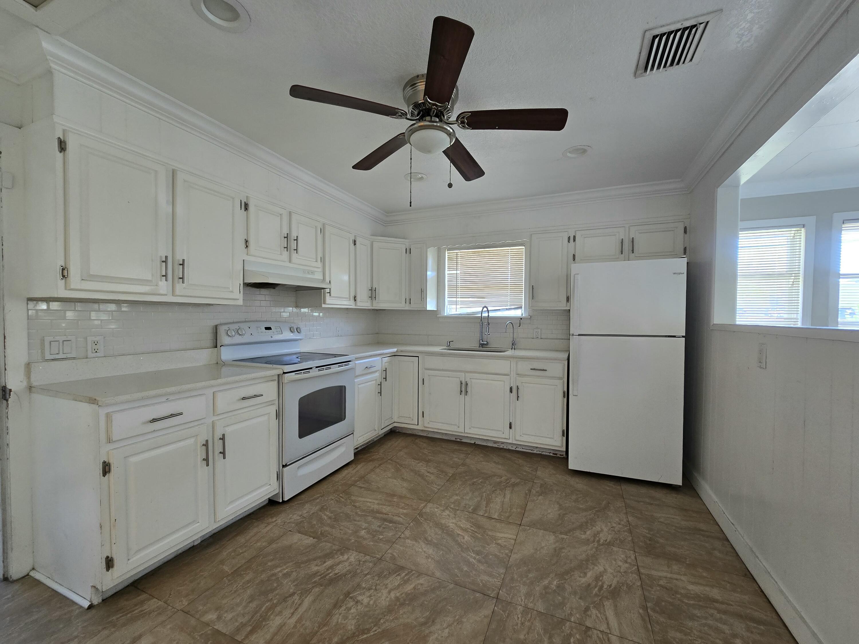 820 Southwest Palm City Road Stuart, FL 34994 - Photo 13 of 24 a kitchen with cabinets stainless steel appliances and a window