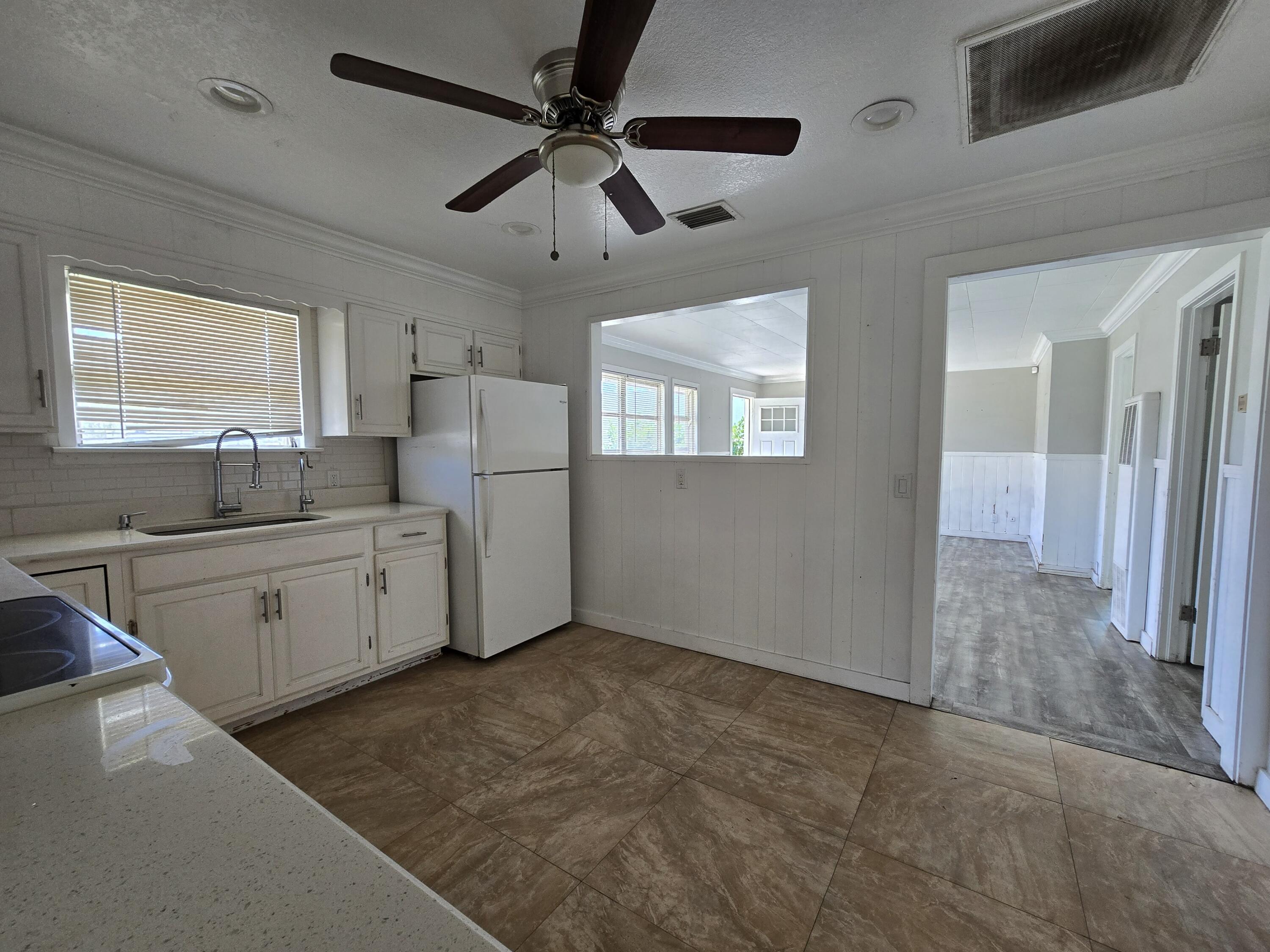 820 Southwest Palm City Road Stuart, FL 34994 - Photo 14 of 24 a kitchen with white cabinets and window