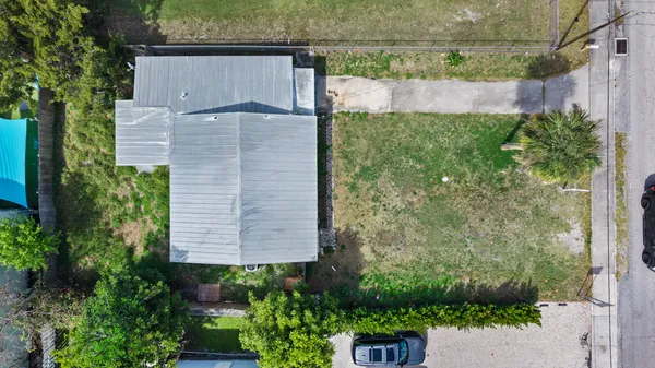 a view of a house with a yard and potted plants