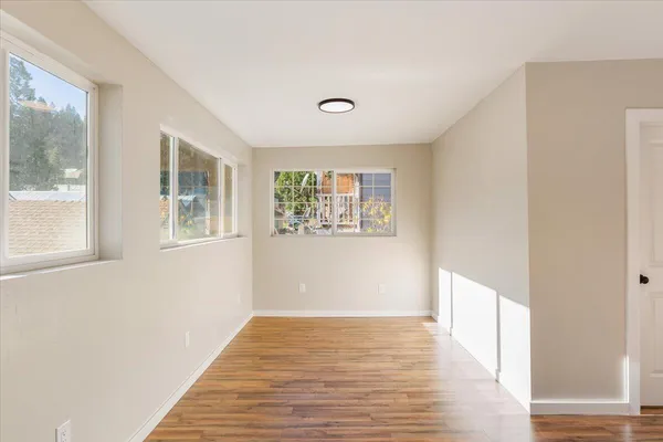 a view of a hallway with wooden floor and a window